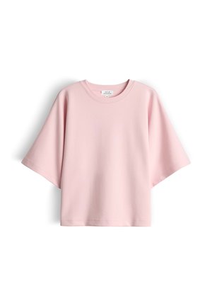 Light pink oversized short-sleeve crew neck shirt with a straight hem, laid flat on a white background.
