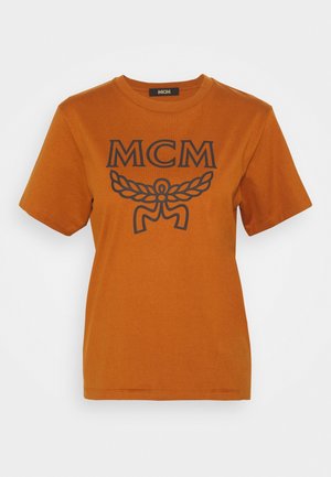 Rustorange kortærmet T-shirt med sort MCM-logo og vinget emblem trykt på brystet, rund halsudskæring og ensfarvet design.