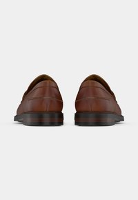 Mocassins en cuir marron à finition lisse, bout arrondi et semelle foncée contrastante. Deux accents de couture horizontale près du talon.