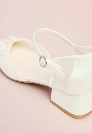 Biała satynowa sandałka na niskim słupku, z kwiatowymi ozdobami, regulowanym paskiem z srebrną klamrą i gładką, wewnętrzną wyściółką.