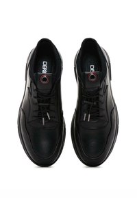 Zapatillas de cuero negro con un acabado suave, que presentan un diseño de cordones, detalles en metal plateado y un logotipo circular en la lengua.