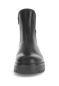 Bota de tobillo de cuero negro con suela gruesa, cremallera frontal y punta redondeada, mostrada en vista frontal sobre un fondo blanco.