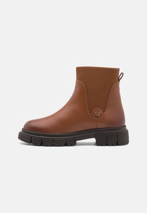 Bottine en cuir marron avec panneau latéral élastique, bout arrondi et semelle en caoutchouc texturée présentant un profond relief pour une bonne adhérence.