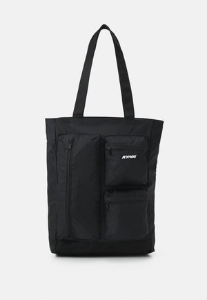 Black tote bag with three front zippered pockets, two long handles, and "K-Way" logo on the upper right pocket.