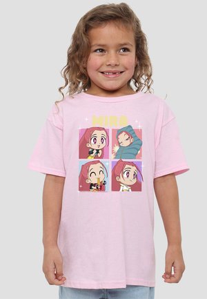 Smiling young girl wearing a light pink T-shirt featuring four colorful chibi-style cartoon faces labeled "MIRA."