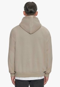 Hue sweatshirt i beige, der har en afslappet pasform, ribbede manchetter og kant. Blødt stof med minimale detaljer. Bagansigt præsenteret.