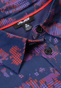 Marineblauwe kortekoo shirt met een geometrisch patroon in rood en paars, met een kraag, twee zwarte knopen en een label met maat S 38.