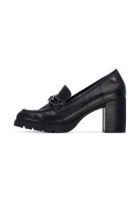 Mocasines de tacón de cuero negro con punta redonda, hebilla decorativa, detalle texturizado en el tacón y suela de goma gruesa.