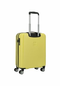 Valigia rigida gialla con dettagli neri, due cerniere, quattro ruote girevoli e un manico telescopico in metallo. Superficie strutturata.