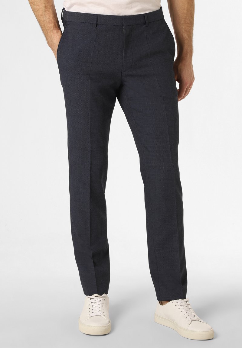 Marineblaue, maßgeschneiderte Hose aus strukturiertem Material mit schlanker Passform. Mit flacher Vorderseite, Gürtelschlaufen und Seitentaschen. Kombiniert mit weißen Sneakers.