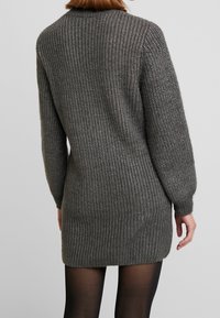 Abito in maglia grigio scuro, con costine verticali testurizzate, maniche lunghe e una vestibilità comoda, che arriva a metà coscia.