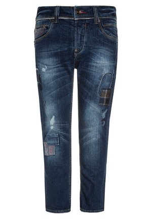 Tmavě modré džíny z denimu s úzkým střihem, zdobené opranými místy, kontrastním šitím a různými texturami tkanin.