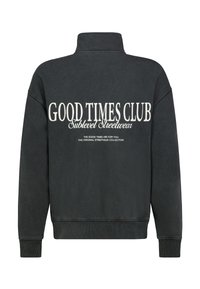 Zwarte sweatshirt met hoge kraag, met grote witte tekst op de achterkant: "GOOD TIMES CLUB Sublevel Streetwear" en aanvullende tekst eronder.