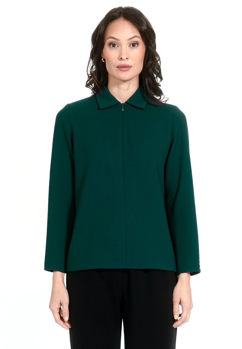 Zaļš garām piedurknēm krekls ar apkakles apkakli un priekšējo rāvējslēdzēju, izgatavots no gluda auduma, ar taisnu griezumu un minimālisma dizainu.