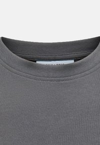 Grauer Kurzarm-Rundhalsausschnitt T-Shirt aus strukturiertem Baumwollstoff, mit einem gerippten Kragen und einem Etikett im Inneren des Kragens.