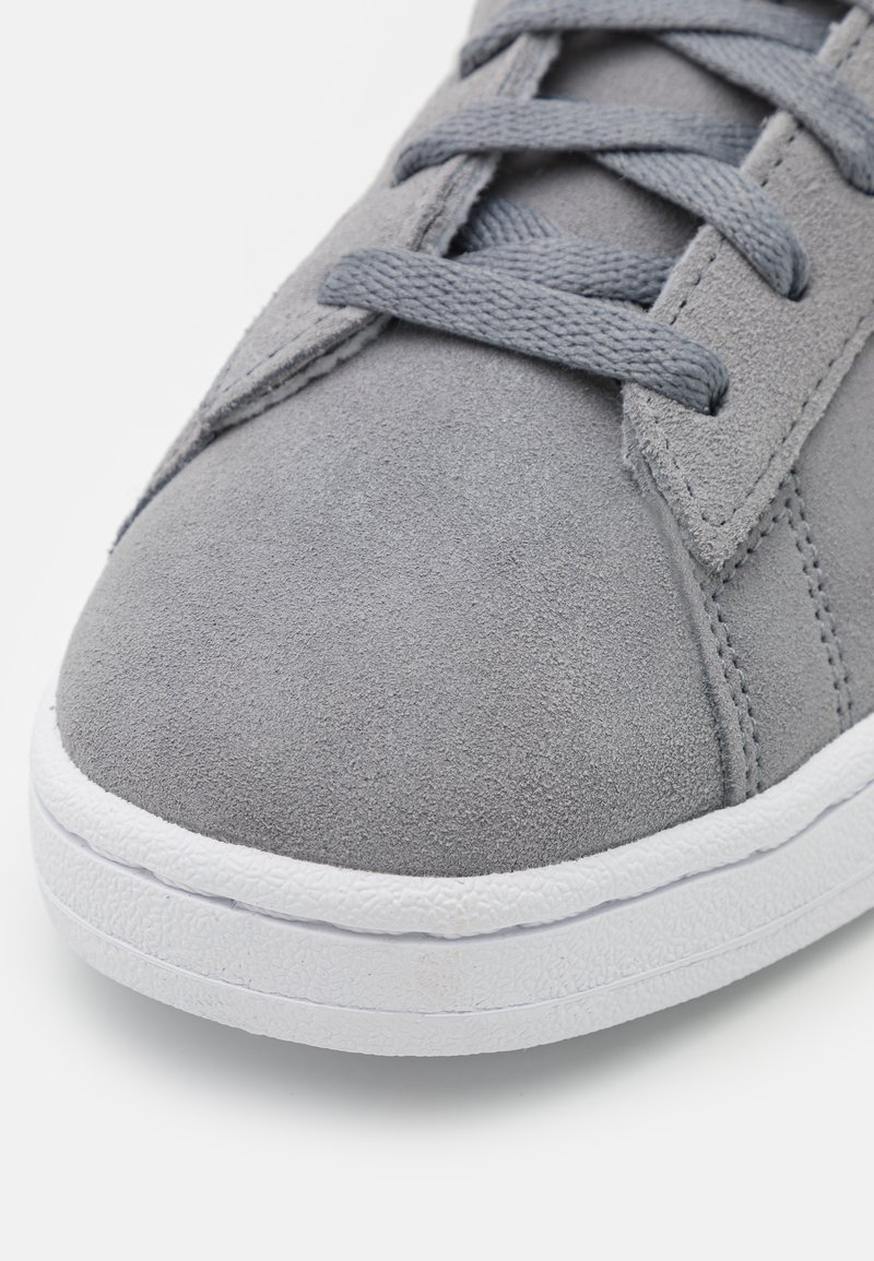 Graue Wildleder-Sneaker mit abgerundetem Zeh, flacher weißer Gummisohle und passenden grauen Schnürsenkeln, die eine glatte Textur und klare Designlinien aufweisen.