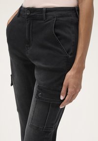 Svarta denim cargobyxor med sidofickor med knäppning, rak passform och synliga sömnadsdetaljer på benen.