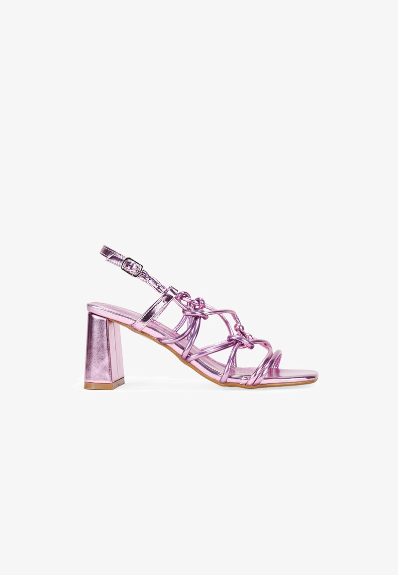 Sandalia de tacón metálica rosa con punta abierta, diseño de correas intrincado y hebilla ajustable en el tobillo. El tacón cuadrado proporciona un soporte estable.