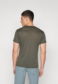 Olijfgroene T-shirt met korte mouwen van een zachte, gestructureerde stof, met een ronde halslijn en een logolabel nabij de zoom.