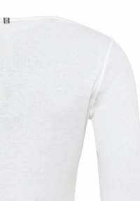 Weißes, geripptes Langarmoberteil aus einem weichen Baumwollmix, mit einem Rundhalsausschnitt und minimalistischen silbernen Metallakzenten auf der Rückseite.