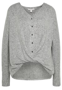 Jasnoszara dzianinowa bluzka z długim rękawem, z czarnymi guzikami z przodu i nakładającym się wykończeniem w talii.