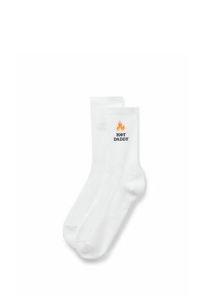 Weiße Sneakersocken mit einer orangefarbenen Flammen-Grafik oberhalb des schwarzen Textes „HOT DADDY“ an der Seite nahe dem oberen Bündchen.
