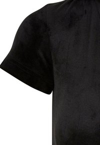 Chemise noire en velours à manches courtes montrant le haut du torse et les détails de la manche.