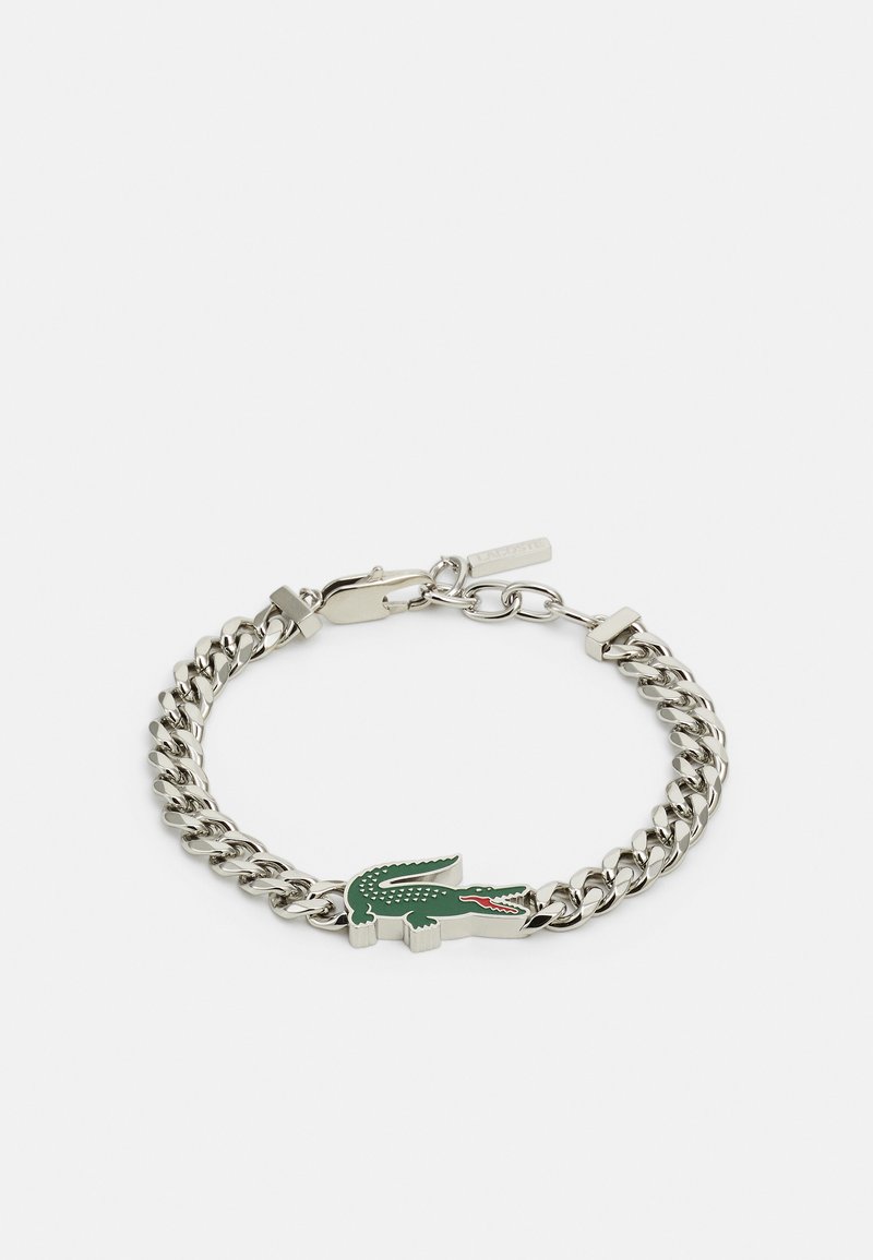 Hõbedane metallist ket bracelet, millel on roheline krokodillikujuline ripats punaste aktsentidega ja karabiinkelgiga sulgur.