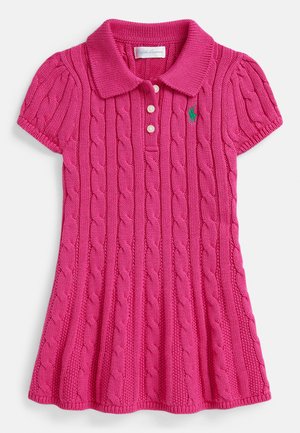 Rožinė megzta polo suknelė su kabelių mezgimo raštu, trumpomis rankovėmis ir apykakle. Suknelė turi tris sagas ir žalią logotipą ant krūtinės.