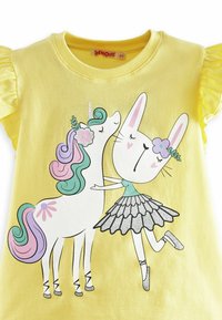 Gul bomulds T-shirt med trykt design af en enhjørning og en kanin iført en tutu, med glimmeraccenter og farverigt hår.