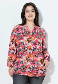 Maglietta a maniche lunghe con un motivo astratto colorato in tonalità di rosa, arancione e grigio, design a scollo a V e vestibilità rilassata.