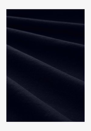 Tissu bleu marine foncé avec une texture douce, présentant de légers plis et creases, mettant en valeur sa surface lisse et sa coloration uniforme.