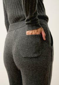 Harmaat, uritetut neulehousut, joissa on sopiva vyötärö, pieni takatasku ja pehmeä, tekstuuriainen kangas.