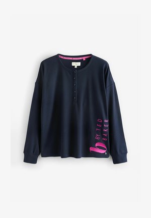 Marineblauw langemouwen top met een henley-halslijn, gestructureerde stof en een roze logo op de mouw. Voorzien van knopen aan de voorkant en geribbelde manchetten.