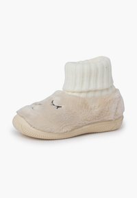 Pantofole in peluche beige con un polsino alla caviglia bianco a coste, caratterizzate da un morbido design facciale e una suola texture per una migliore aderenza.