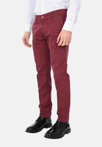 Chinos color bordeaux realizzati in misto cotone, con taglio dritto, tasche frontali e chiusura con bottone. Abbinati a scarpe eleganti nere.