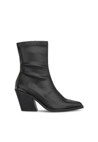 Botas de tobillo negras de cuero suave con punta afilada, silueta elegante y un bloque de tacón distintivo. Costura decorativa en la parte superior.