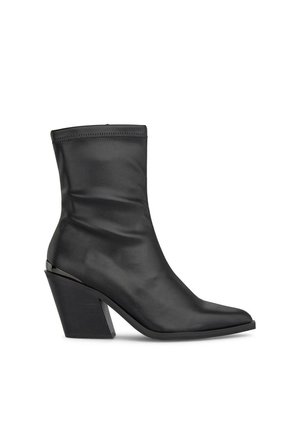 Botas de tobillo negras de cuero suave con punta afilada, silueta elegante y un bloque de tacón distintivo. Costura decorativa en la parte superior.