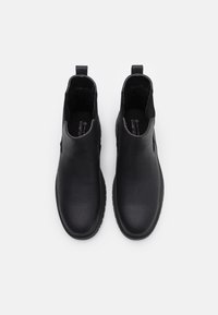 Czarne botki za kostkę wykonane z gładkiej skóry, z elastycznymi panelami bocznymi, okrągłym noskiem i teksturowaną gumową podeszwą dla lepszej przyczepności.