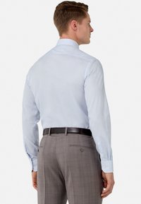 Light blue long-sleeve dress shirt with a slim fit, paired with gray plaid trousers, featuring a waistband and two back pockets.