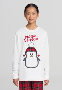 Biała bluza z długim rękawem z napisem "Magic Season" i wzorem pingwina w czerwono-czarną kratę. Miękka w dotyku.
