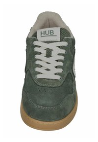 Groene suede sneakers met witte veters, beige gewatteerde kraag, gomzool en "HUB" logo op de tong, gezien van voren.