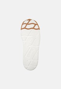 White rubber sole with a textured surface, featuring a brown accent near the toe and a patterned tread for grip.
