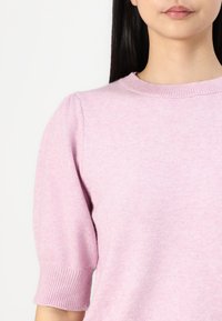 Light pink knit sweater featuring short puff sleeves and a round neckline with ribbed accents. Soft texture with a subtle sheen.