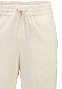 Helle beige, elastische Hose mit einem Kordelzug, seitlichen Taschen und einer glatten, weichen Textur. Schlichtes, gerades Bein Design.