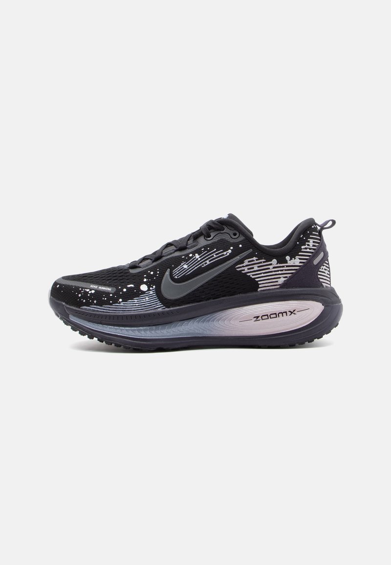 Černé a šedé běžecké boty Nike ZoomX s abstraktními bílými vzory, černým logem swoosh a silnou polstrovanou podrážkou na bílém pozadí.