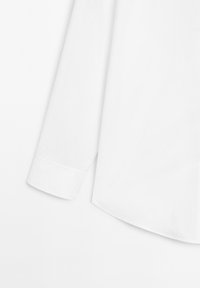 Camicia bianca a maniche lunghe, in cotone, con colletto classico e orlo arrotondato, caratterizzata da una texture liscia e polsini con bottoni.