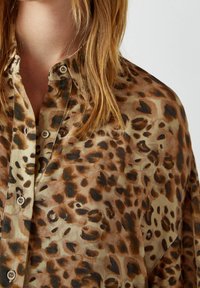 Leopardenmuster-Bluse aus einem glatten, leichten Stoff in Braun- und Beigetönen, mit knöpfbarem Front und lässiger Passform.