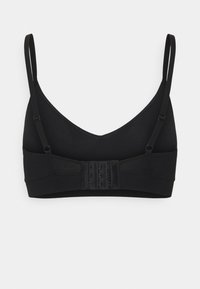 Soutien-gorge sans fil noir avec un design en V, des bretelles ajustables et une fermeture à crochets et œillets à l'arrière. Texture de tissu lisse.