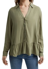 Blusa verde oliva a maniche lunghe con colletto, chiusura con bottoni frontale e orlo a peplum. Tessuto morbido e leggero con una texture liscia.